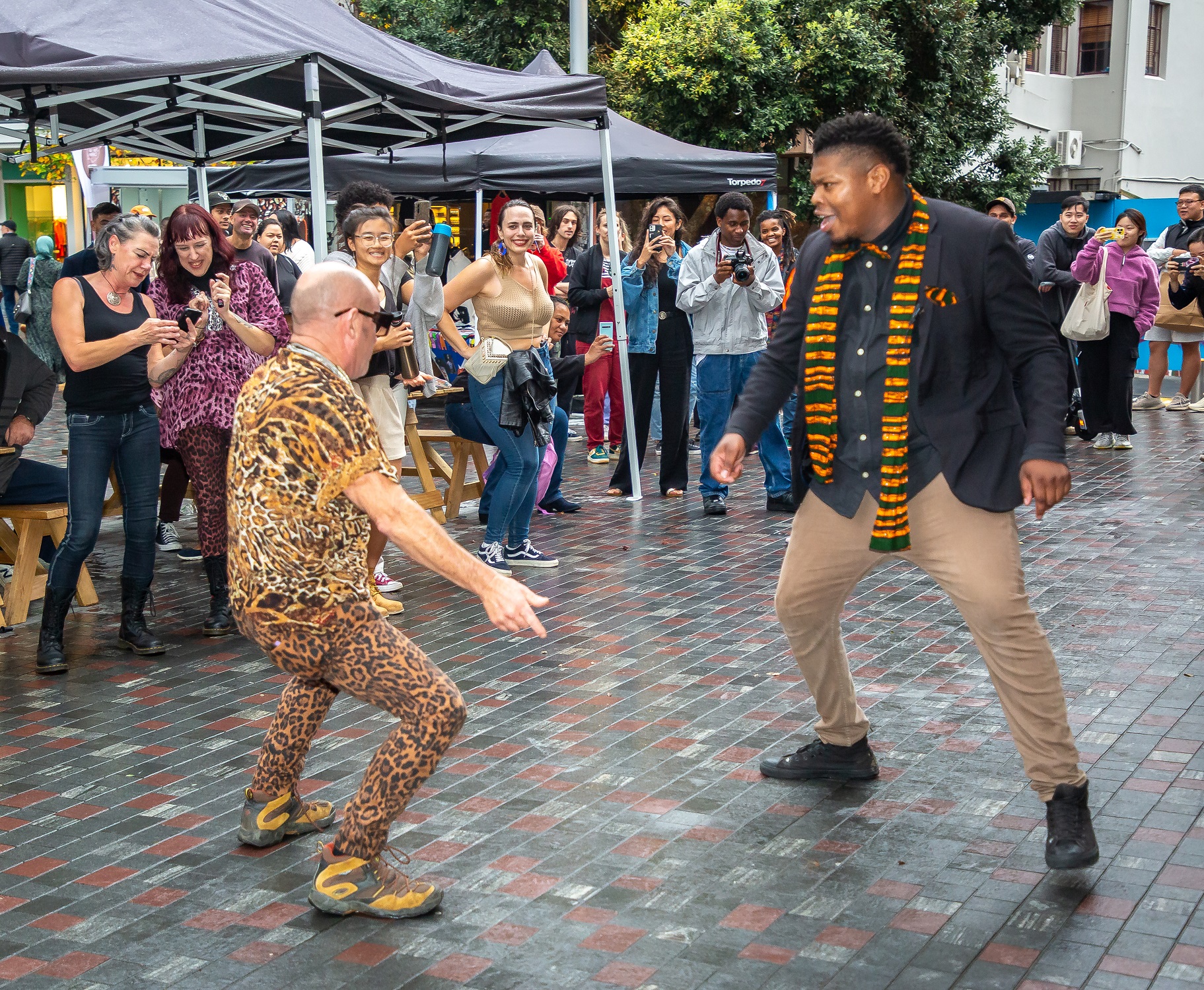 Two men, one European and one African having a dance-off.