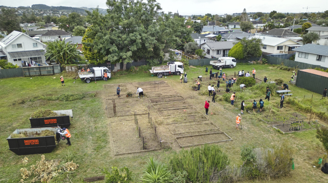 Aerial overlooking community garden with locals hard at work