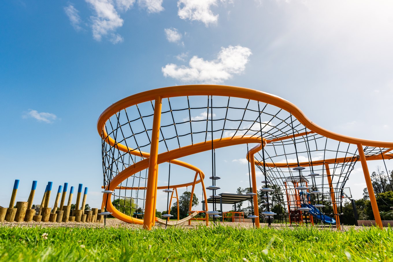 The new playground at Pearl Baker Reserve features a colourful climbing net tower, ninja logs, swings, a mini ground trampoline, a carousel/spinner and a preschool adventure mini tower.