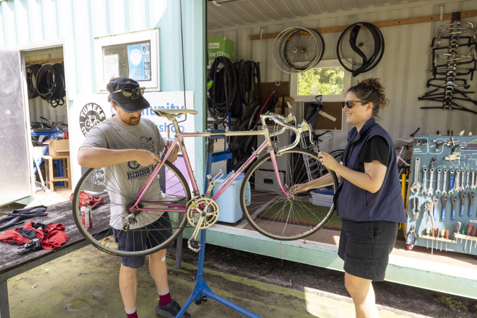 Two bike experts repairing a bike.