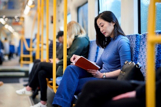 A female reading a book an a train