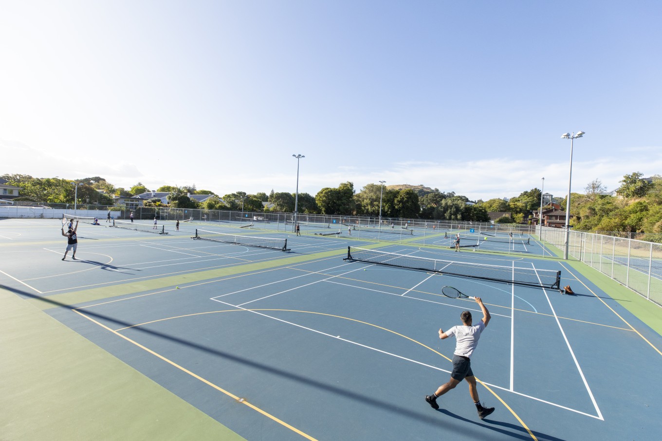 People playing tennis at Windmill Park Tennis Court. 