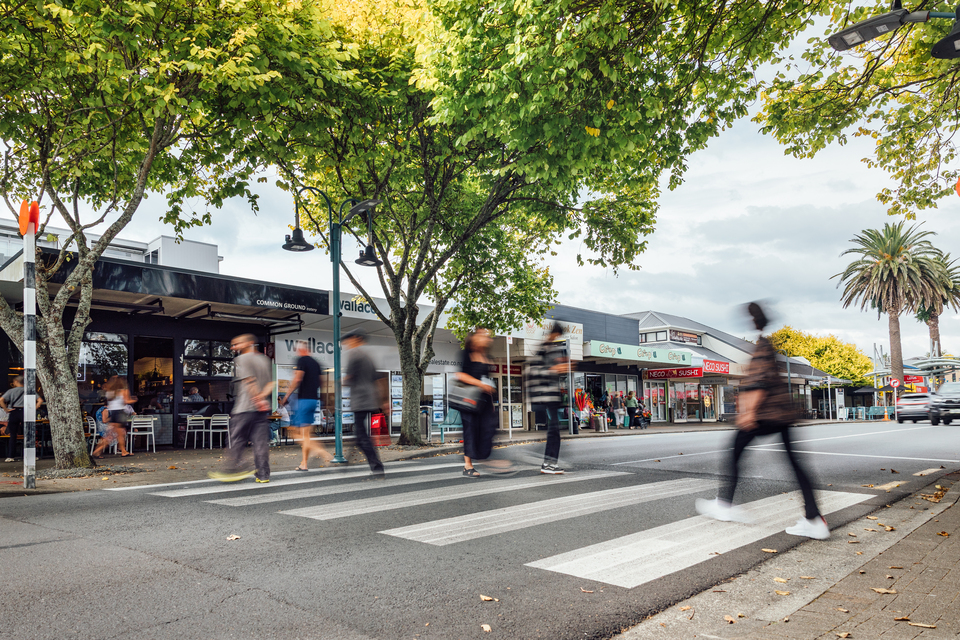 A blurred image of people crossing the street. 