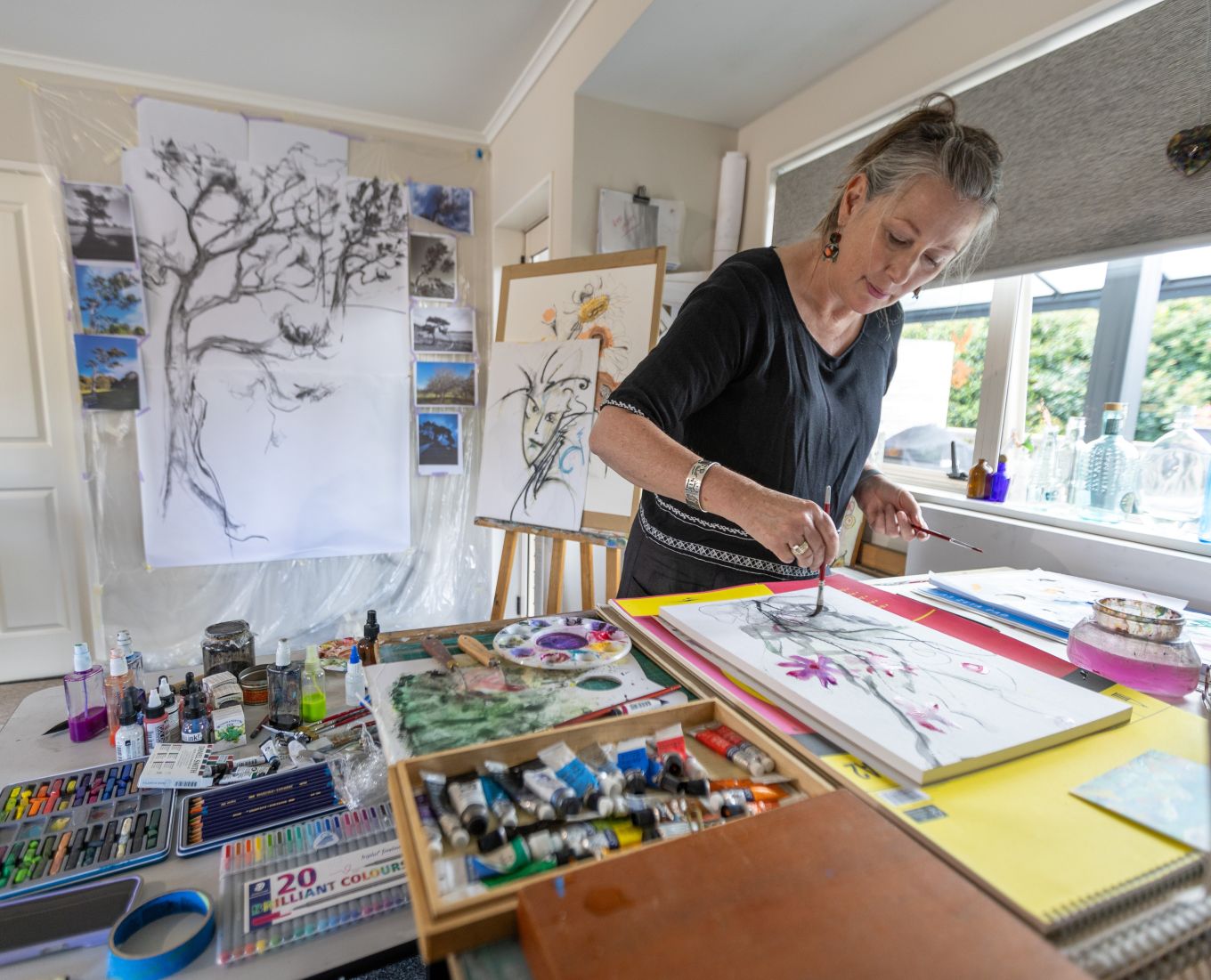 A lady painting a image in a art studio. 