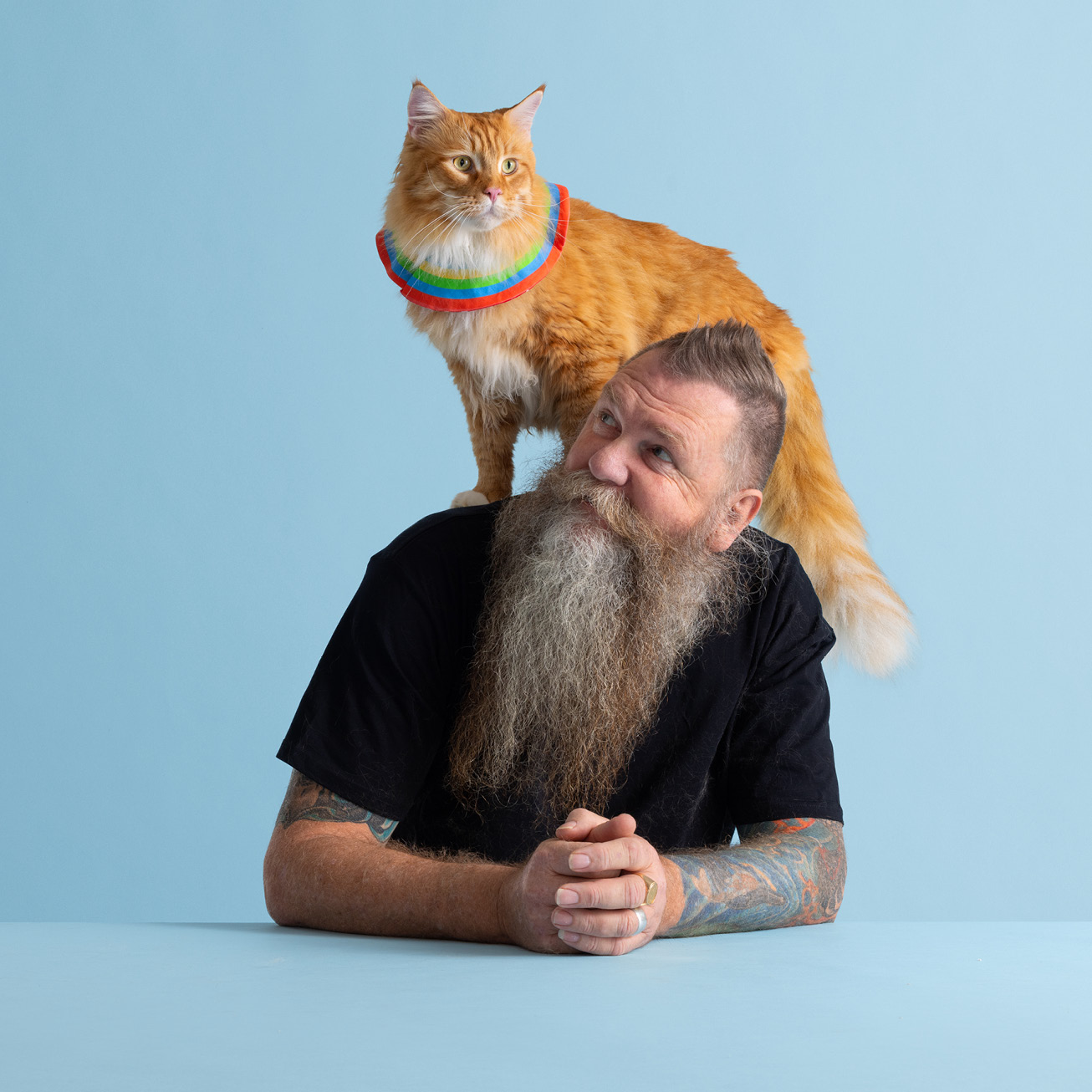 Man looking up at ginger cat that is sitting on is shoulders