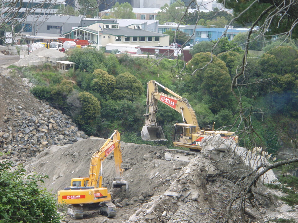 Two diggers clearing away rubble at a landslide affected area.