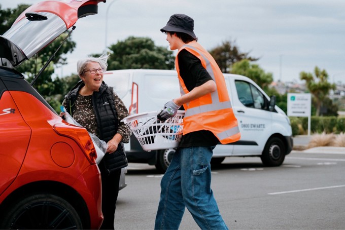 Young worker helping carry e waste for older woman