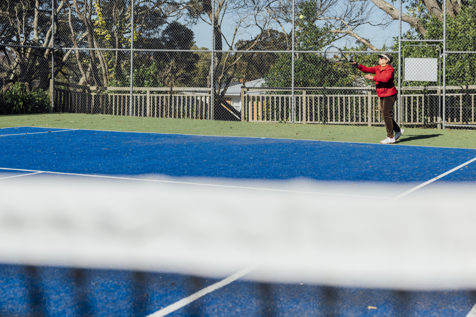 Person playing tennis at Konini Reserve's newly resurfaced court.