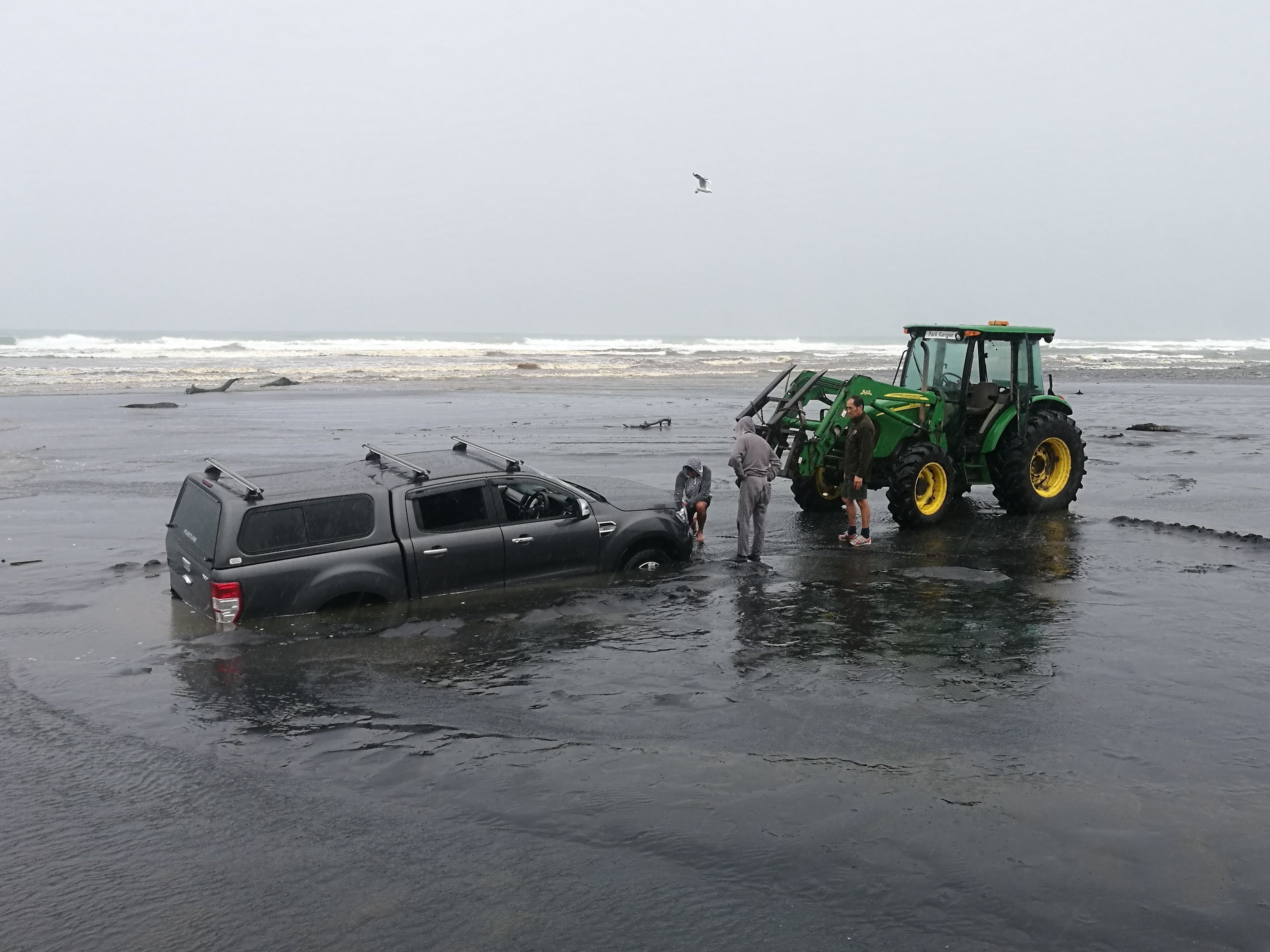 Auckland Council Park Ranger rescuing a 4WD before it gets damaged by the incoming tide