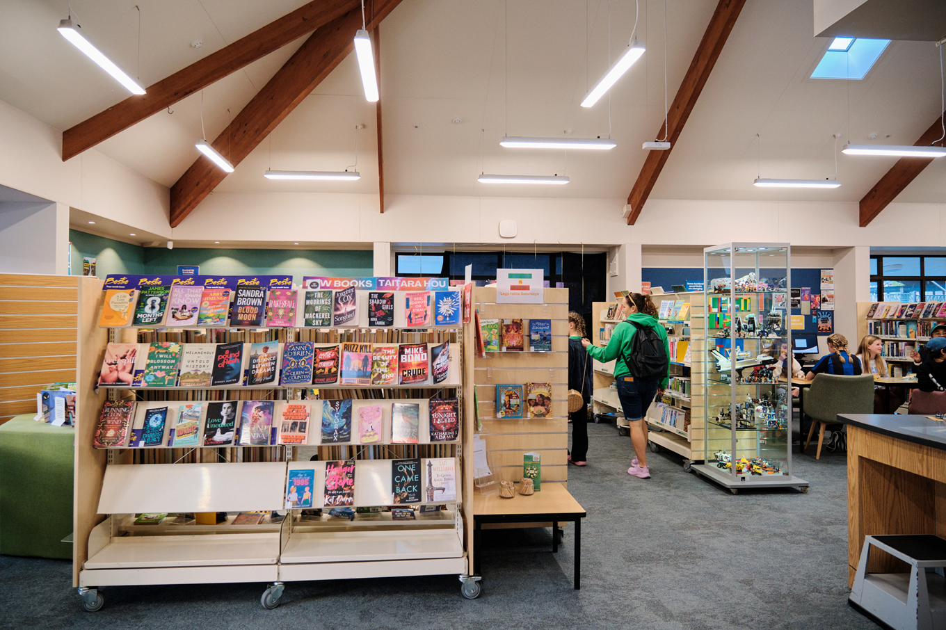 Book stands at a community library where locals are enjoying the library facilities. 
