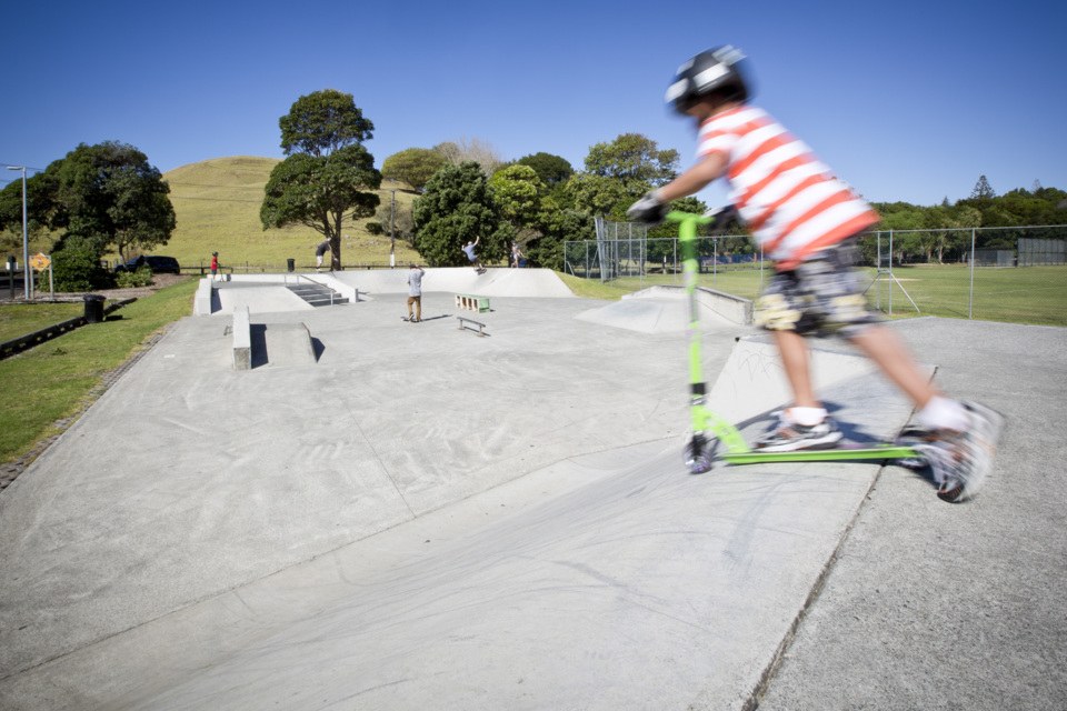 Action shot of a child using a scooter at the Crossfield Skatepark