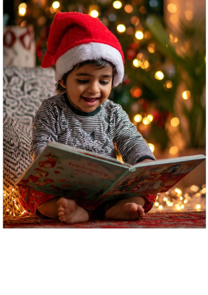 Indian toddler in santa hat reading a book OA_5idgizgd.png