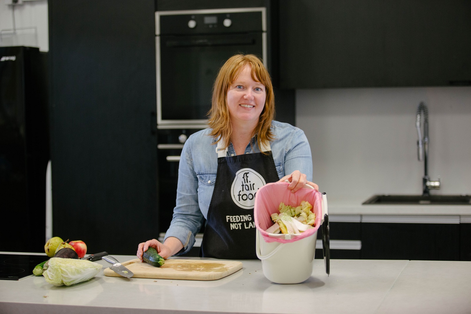 Michelle Blau of Fair Foods with food scraps in the kitchen caddy.