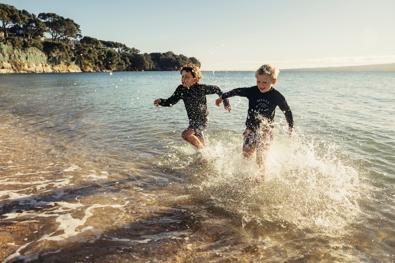 Two kids running through the water.