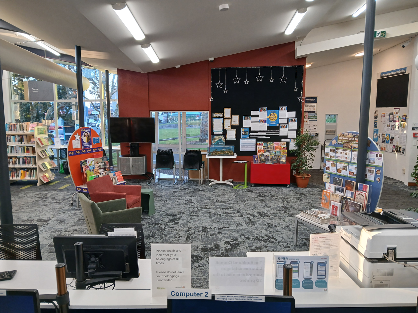 A community billboard and front desk at a local library. 