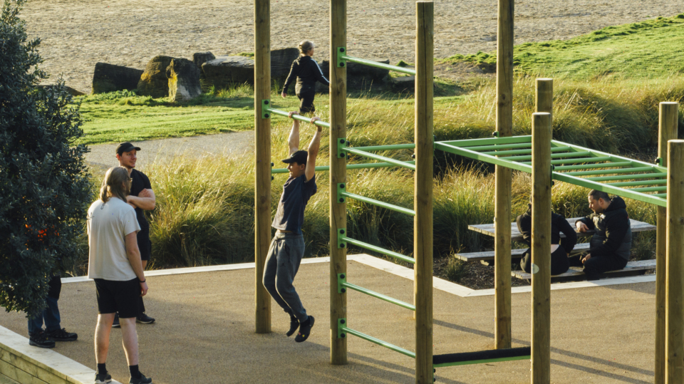 Person testing out chin up bars at Onehunga Bay Reserve's new outdoor gym.