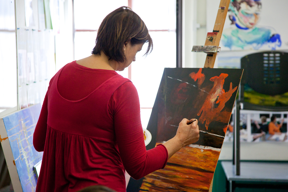 A women painting on a canvas. 
