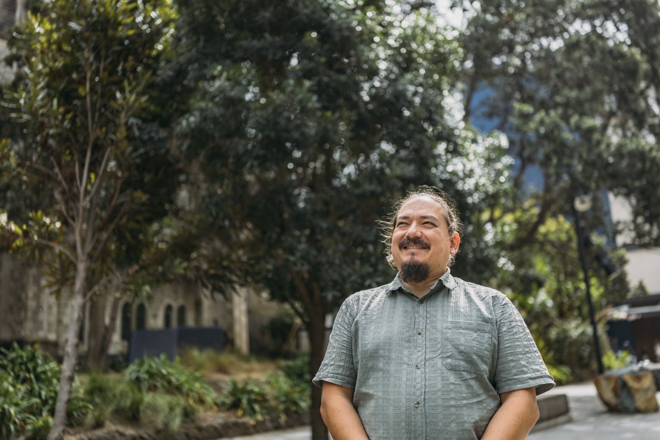 A guy walking down a nature inspired lane. 