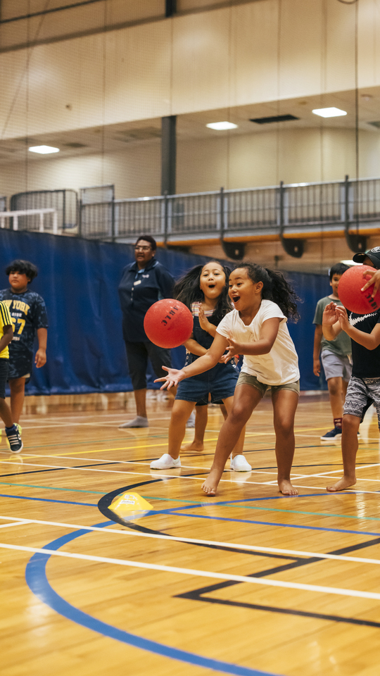 Kids playing basketball on a basketball court. 