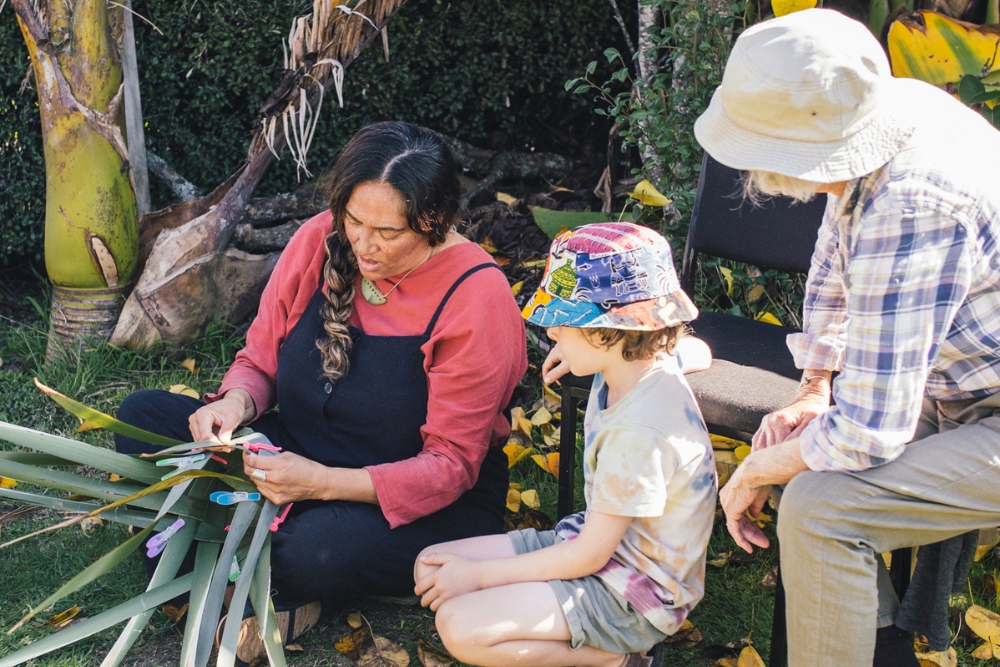 A woman using harakeke flax to weave.