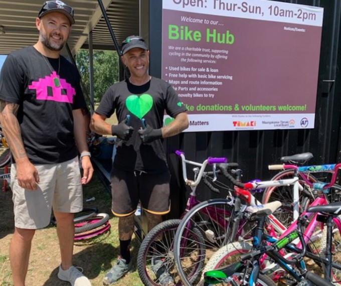 Two men by a bike shed