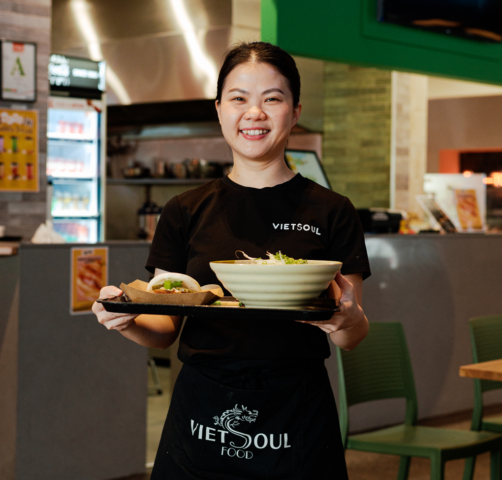 A lady serving Vietnamese food on a tray