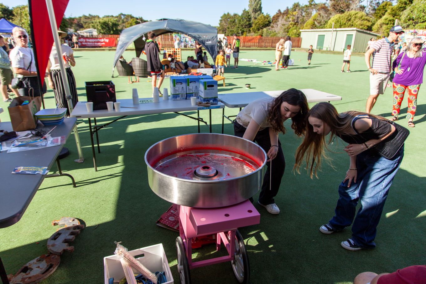 Two young ladies making cotton candy. 