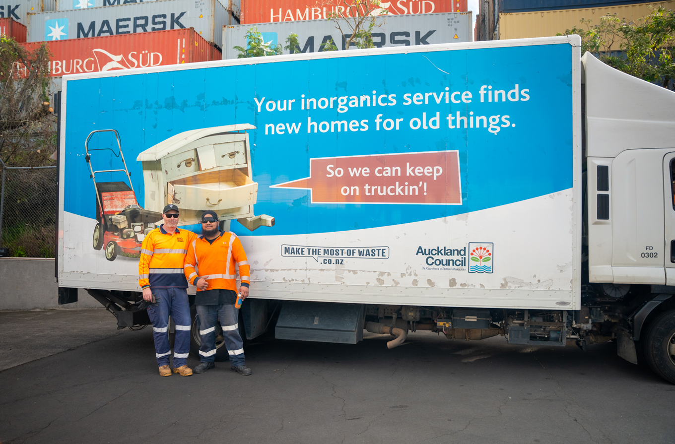 Two workers driving a truck collecting inorganic collections. 