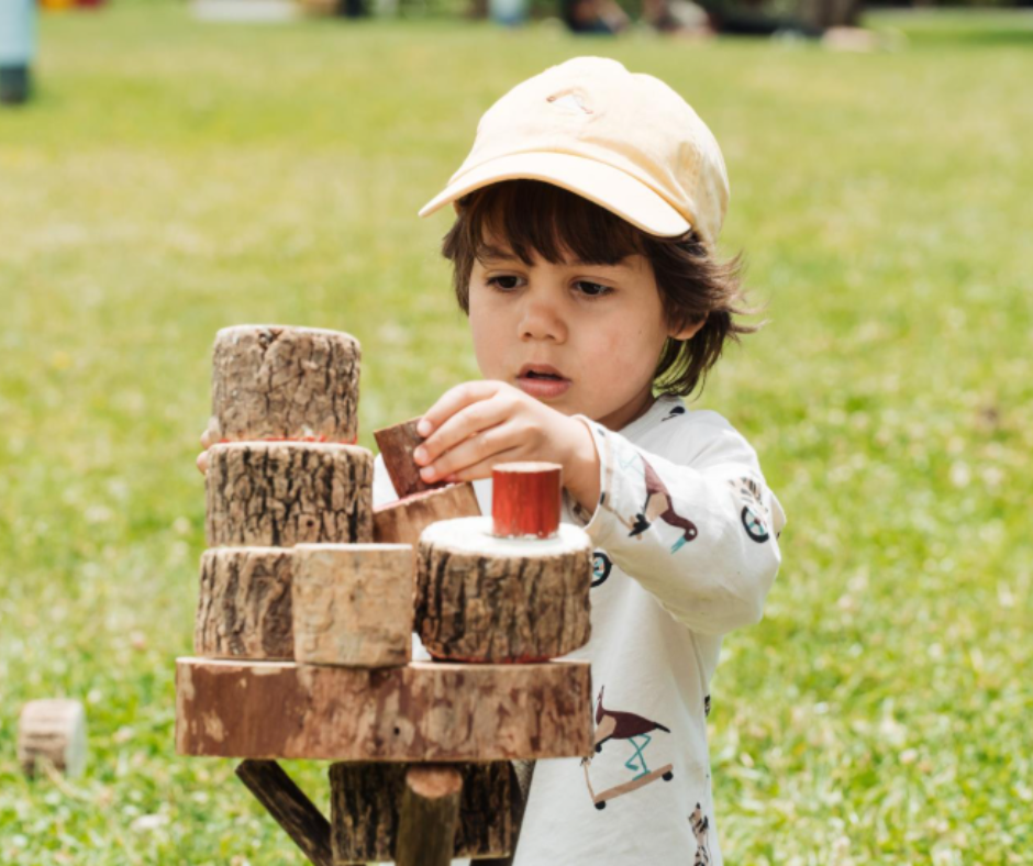 A child stacking wood blocks on top of each other. 