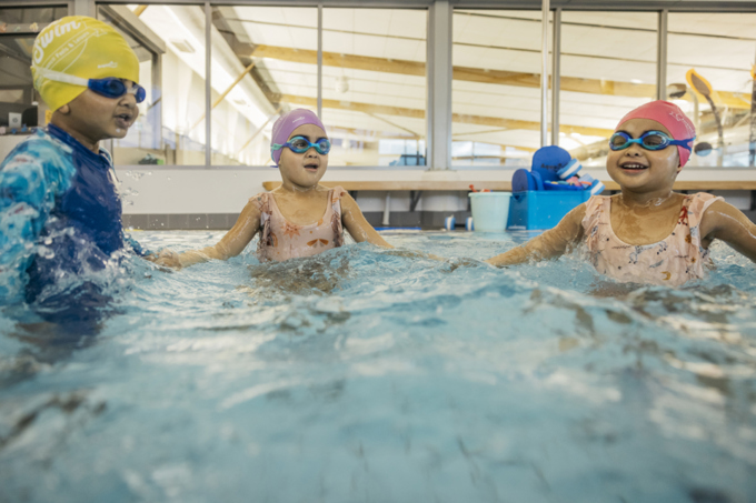 Young children swimming in a community pool