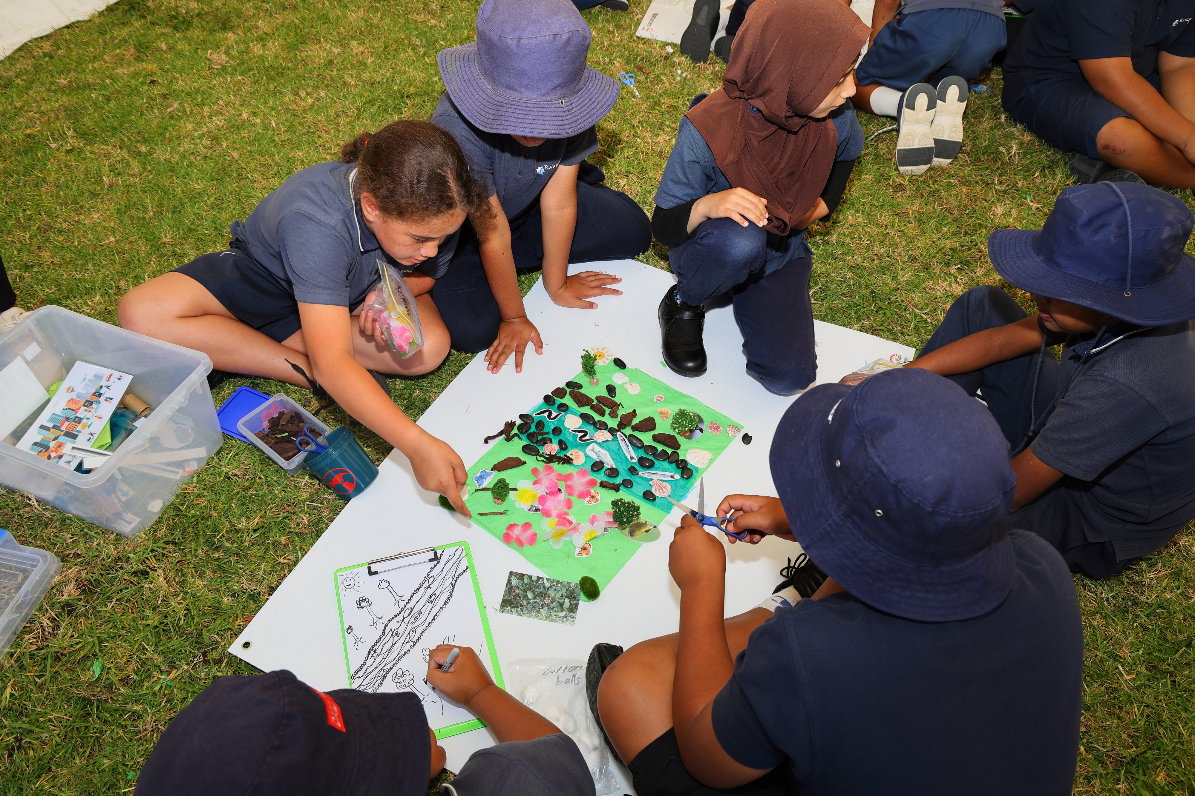 Circle of students participating in nature-inspired craft actitivity in the outdoors.