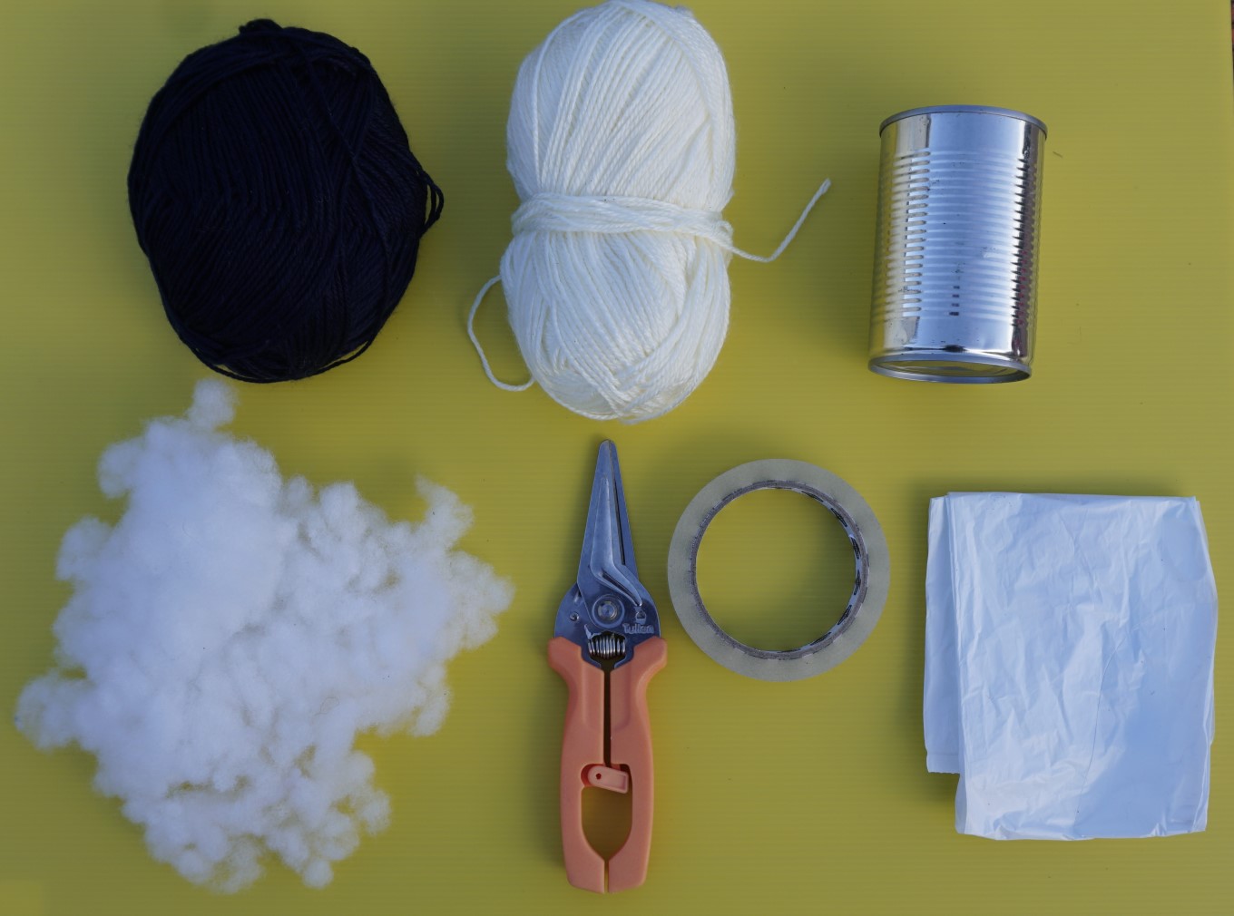 Making a poi - balls of wool, tin can, scissors, stuffing, tape and string