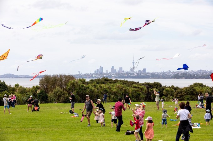A group of people flying kites in a sunny park