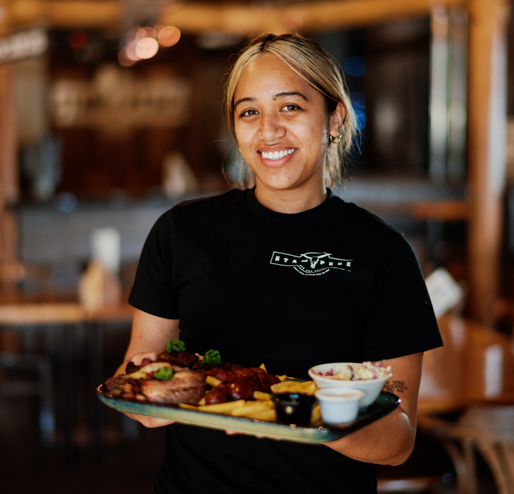 A young women serving up food on a tray