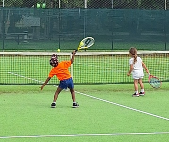 Two kids playing tennis