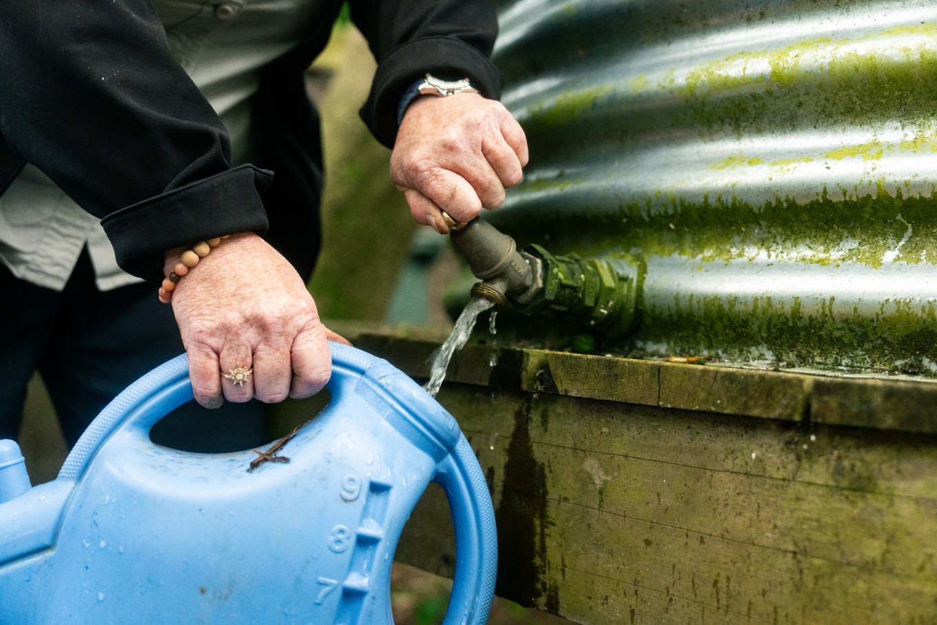 A person filling up their water canister. 