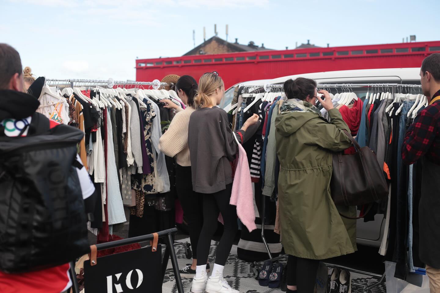 Shoppers rummaging through Koha Apparel's clothing racks at Auckland Central Market