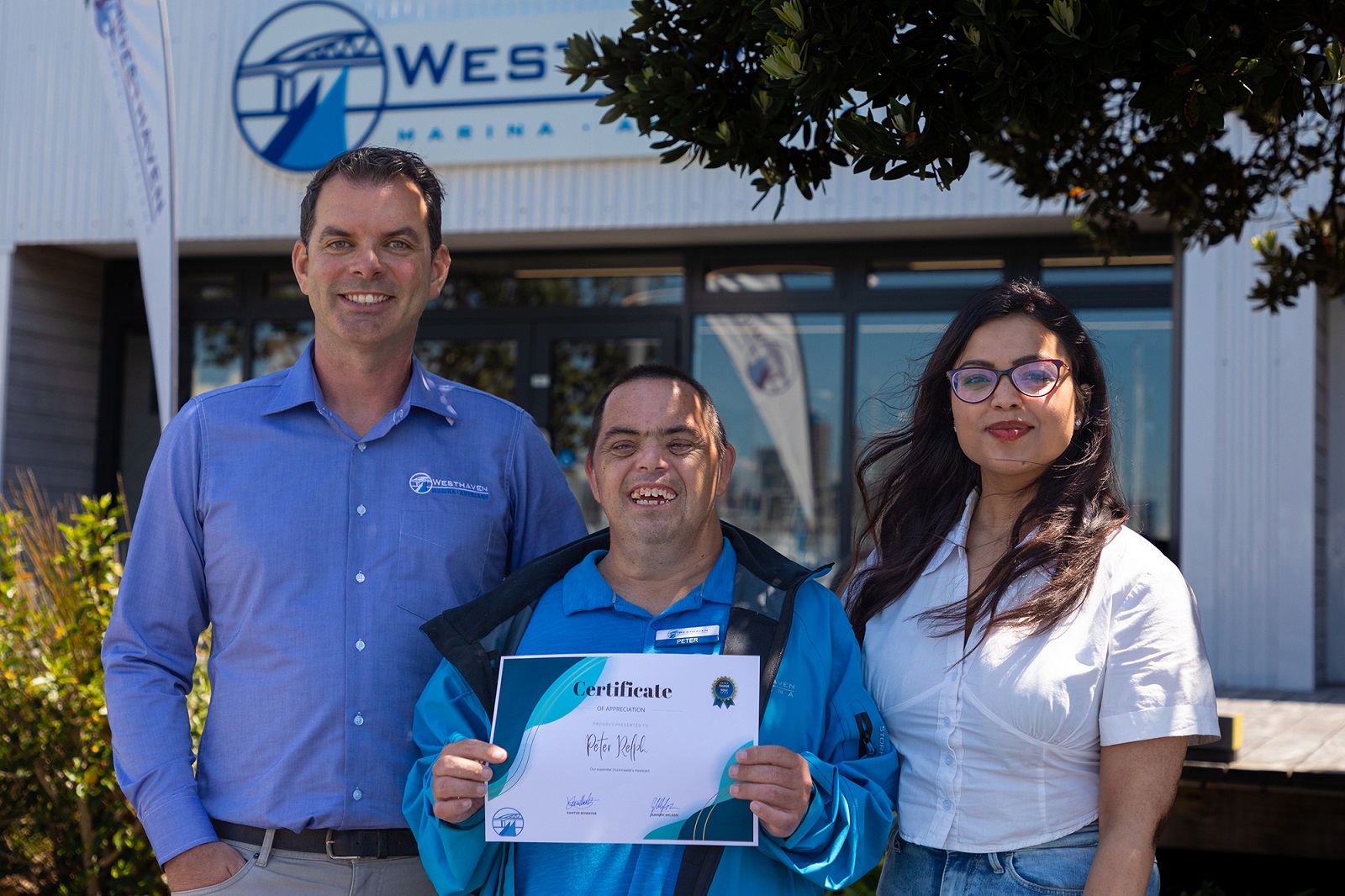 (Left to right): Westhaven Marina manager, Gareth Wilson, Peter Relph, and Spectrum Care community facilitator, Ojasvi 'OJ' Singh