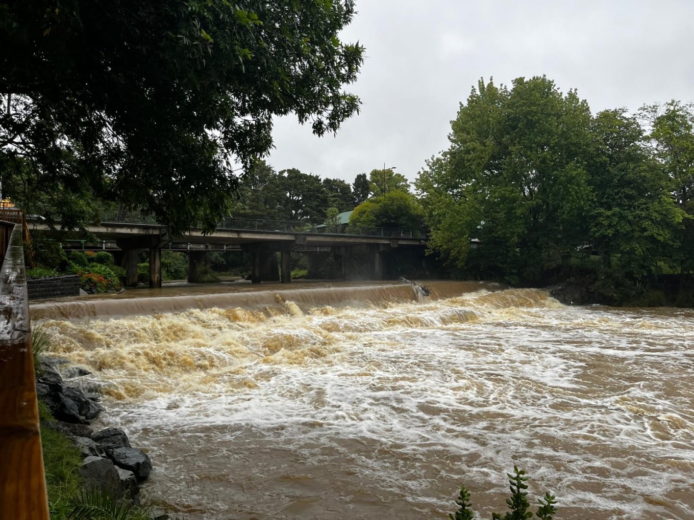 A flooded river under a bridge.