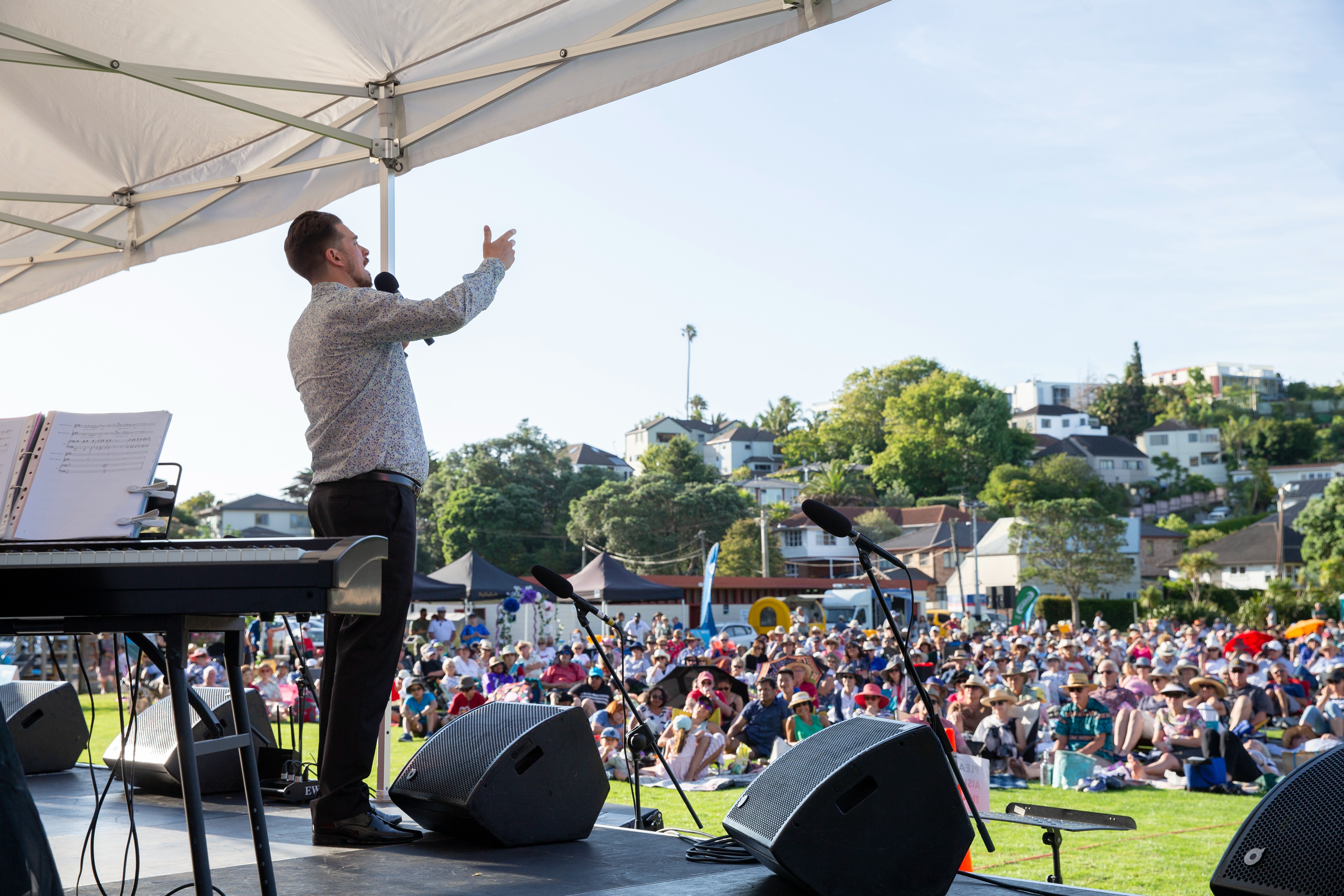 An opera performer sings to a crowd of people at Glover Park, St Heliers.