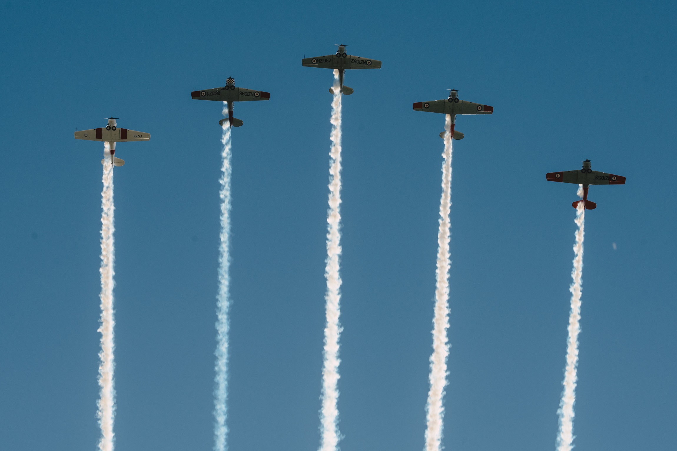 5 warbird planes flying overhead with vapour trails