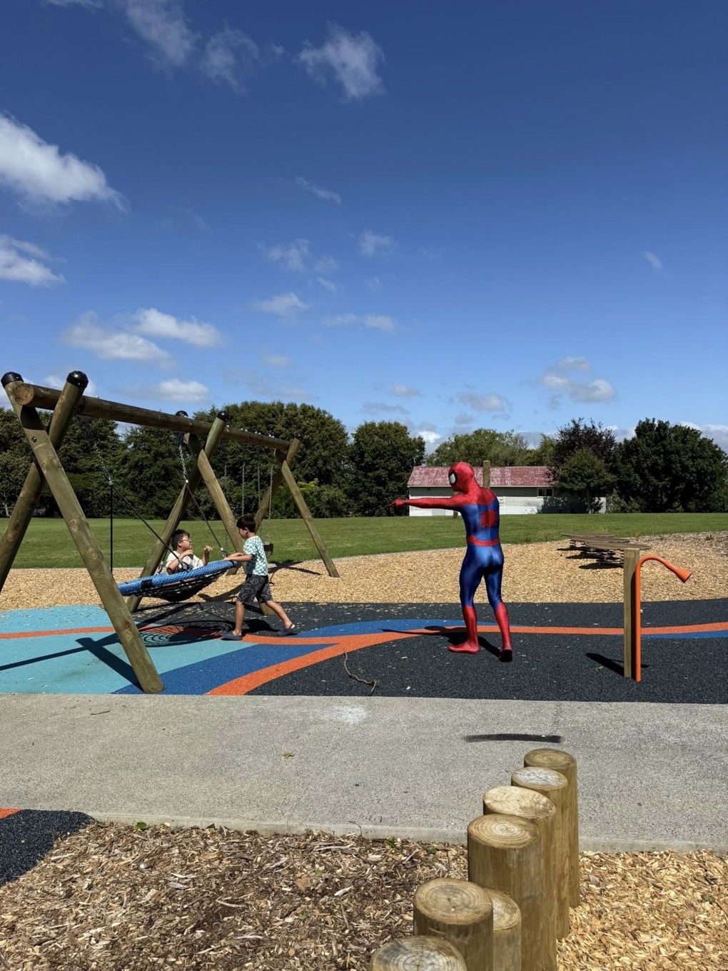 Spider man playing with kids at a local playground