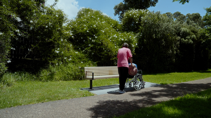 A person pushing another person in a wheelchair