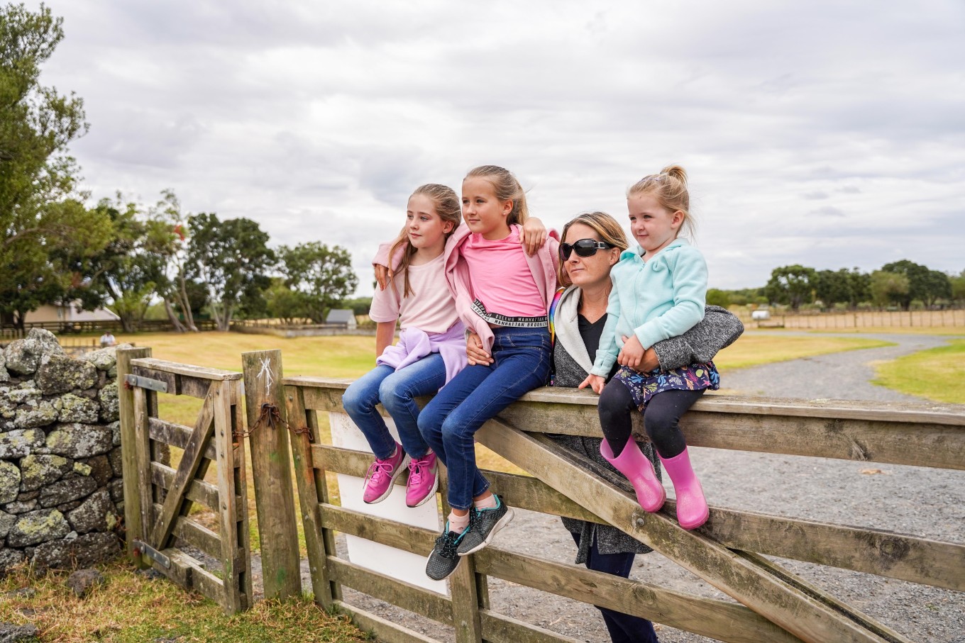 A family enjoying views while sitting on a gate.