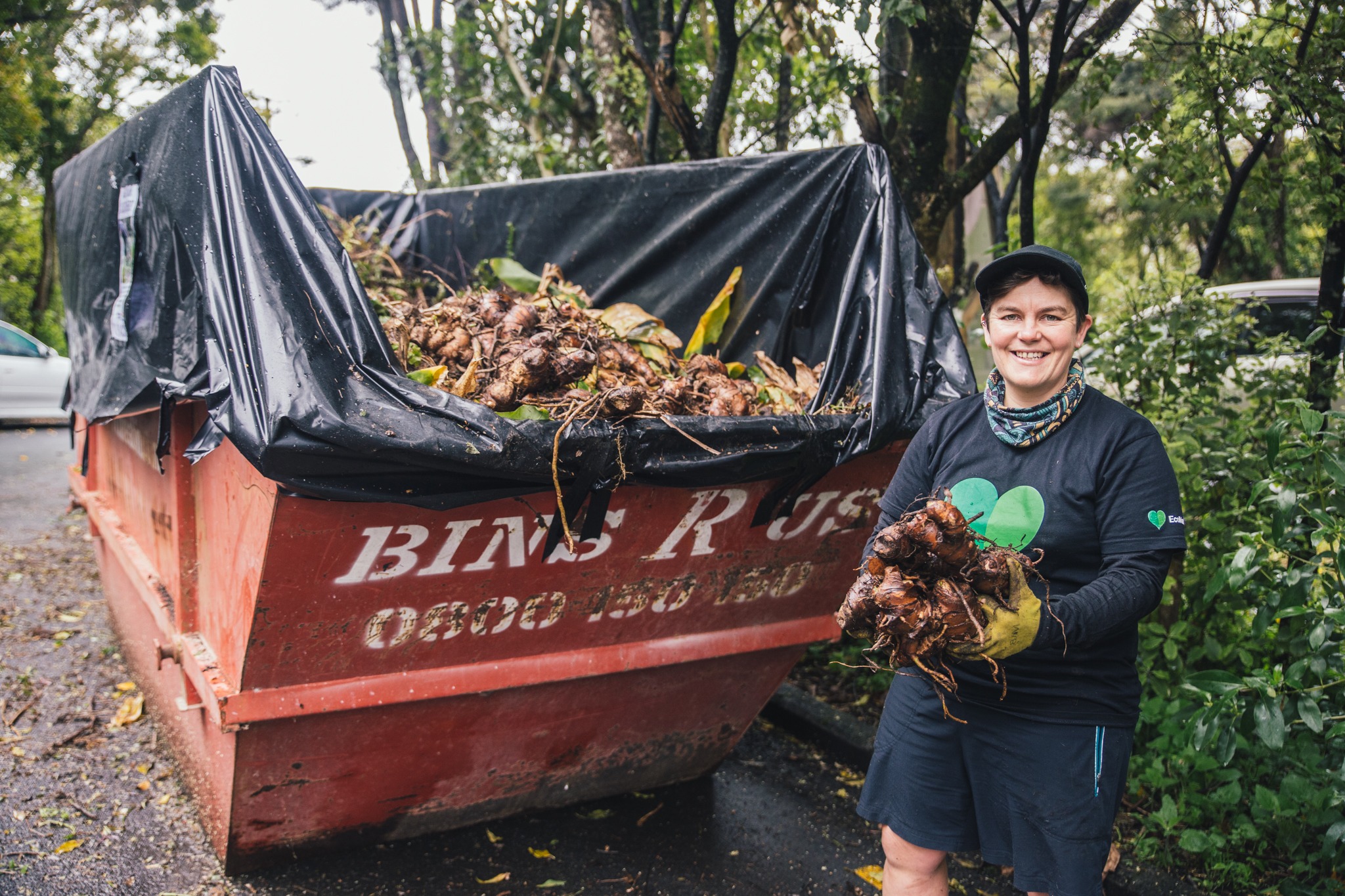 A lady with a giant weed bin. 