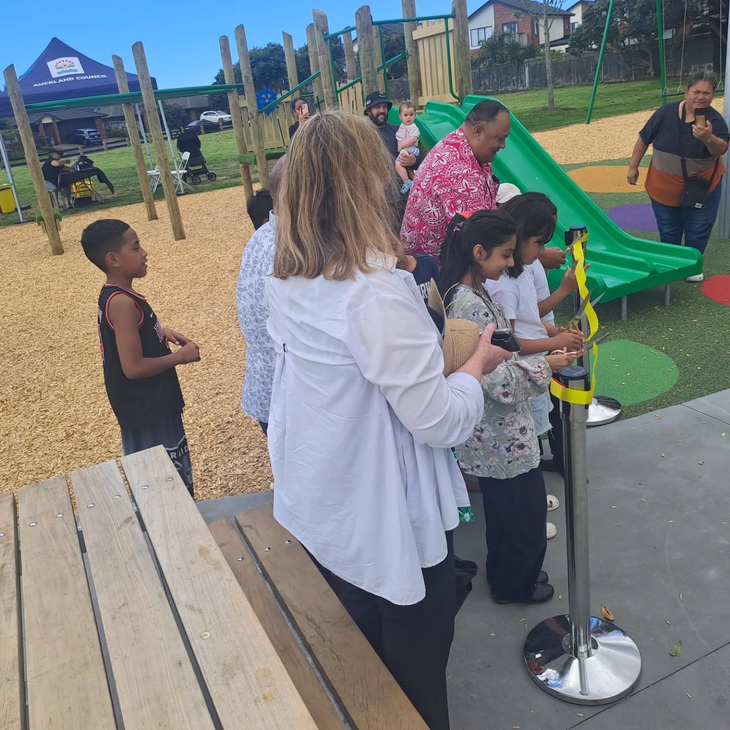 A local community attending a opening for a playground. 