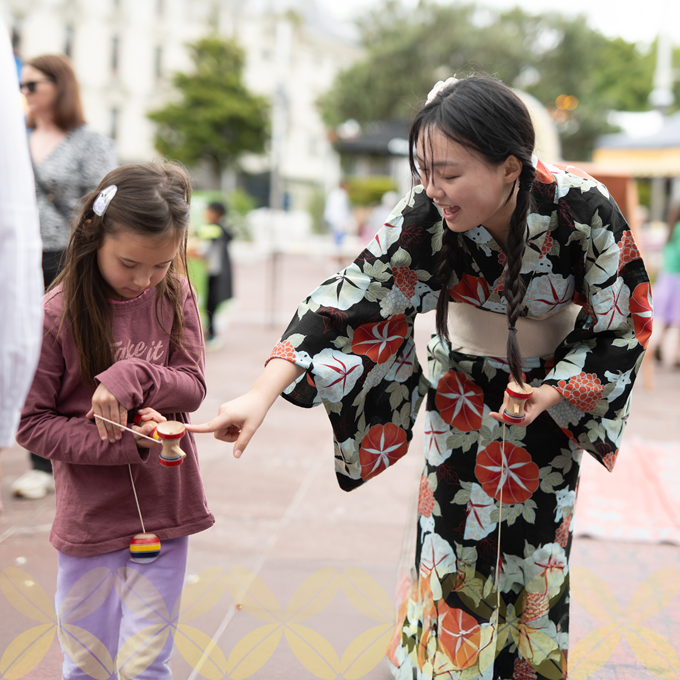 A lady in a kimono playing with a younger child