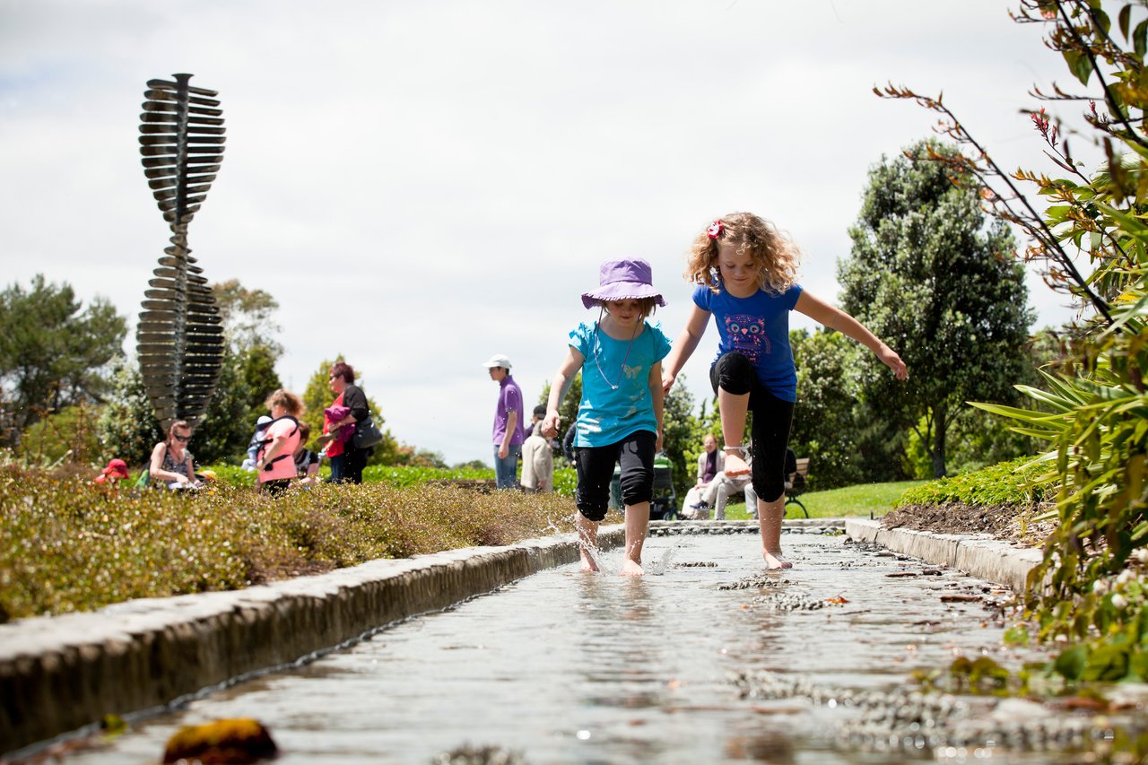 Children playing in the puddles around Auckland Botanic Gardens. 