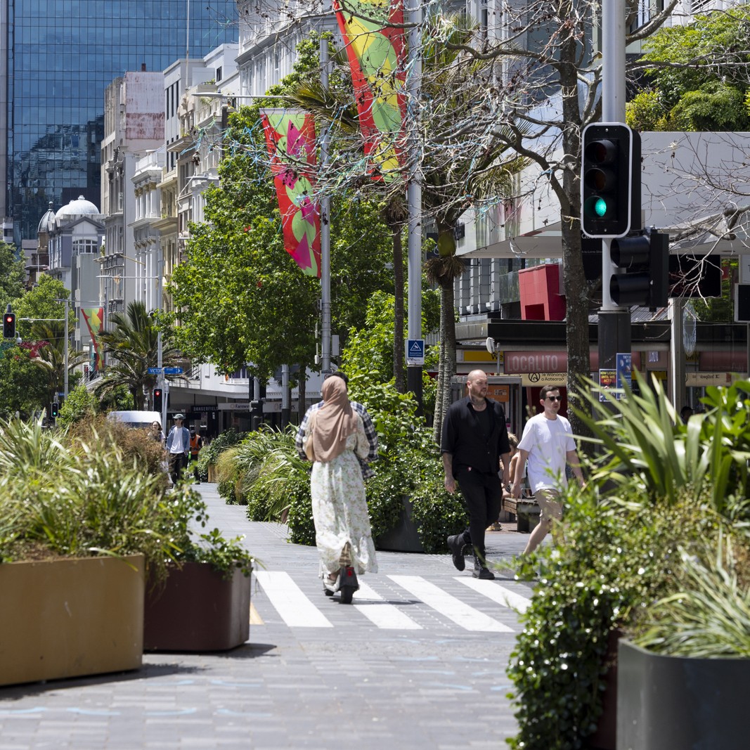A woman riding on a e-scooter around Auckland City Centre.