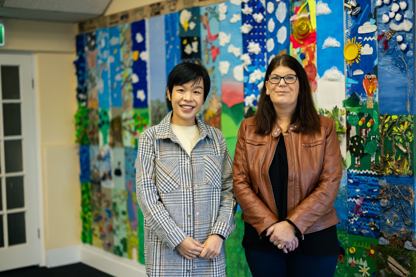 Waiōrea Community Recycling Centre manager Christine Wang (left) and MPHS CEO Kathryn Lawlor had local schools and early childhood centres create a mural for the facility using upcycled materials.
